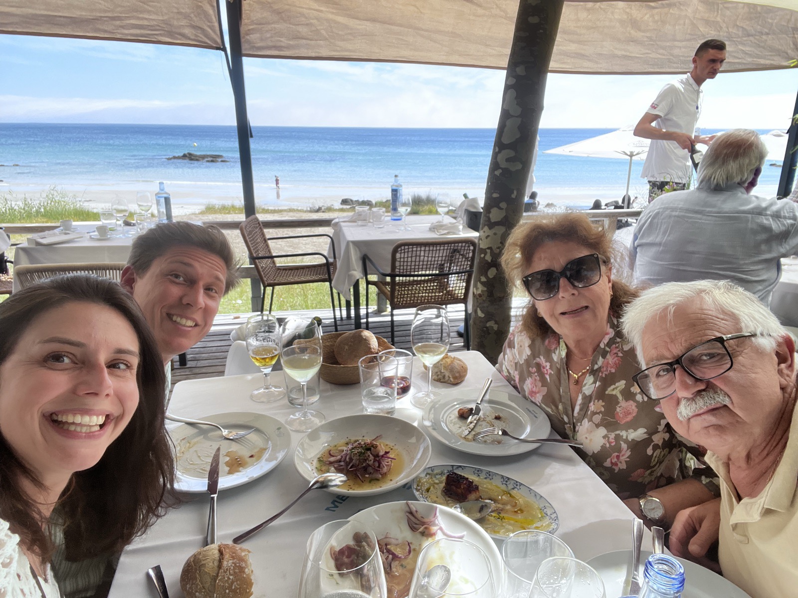 The family at a beachfront paella lunch with the bay behind